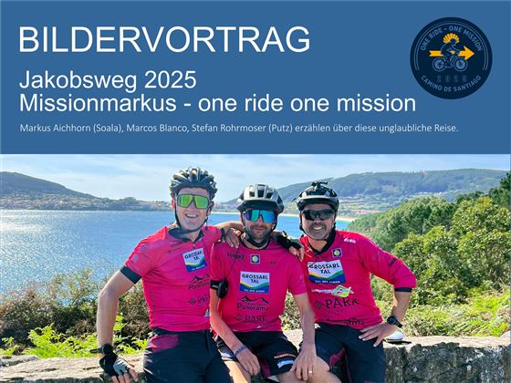 Drei Radfahrer tragen pinke Trikots und lächeln in die Kamera. Im Hintergrund ist eine schöne Landschaft mit Bergen und Wasser zu sehen.