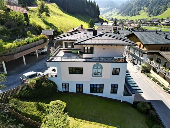 A modern building in a picturesque mountain landscape. The surroundings are green and invite relaxation.