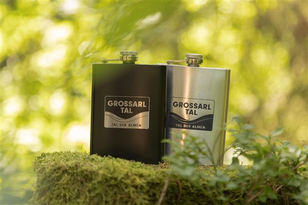Two flat men stand on a moss-covered stone in nature. They are in black and silver, with a label that shows "GROSSARL VALLEY."
