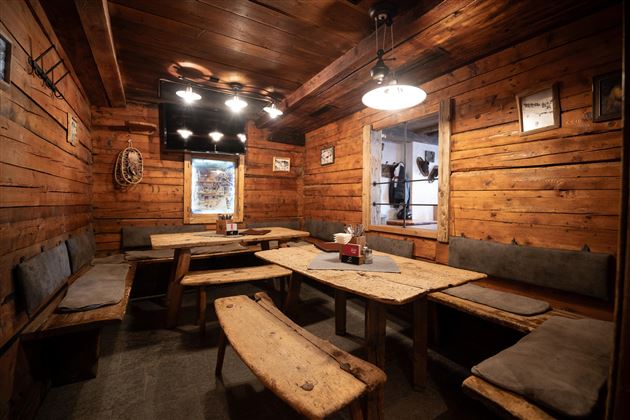 A cozy room with wooden walls and wooden furniture. The room is simply furnished and offers space to sit and relax.