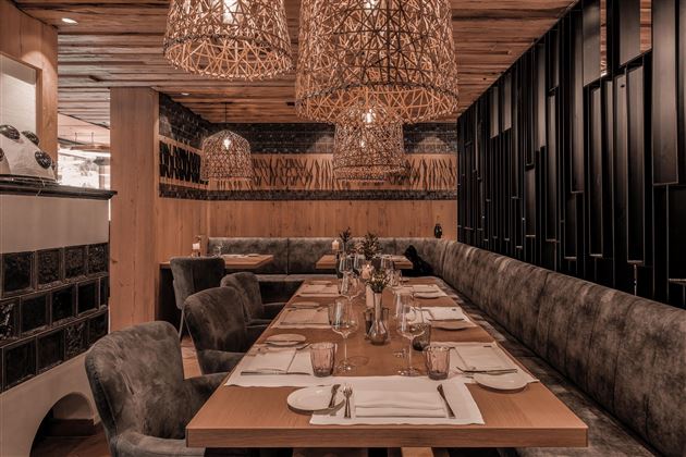 A stylish restaurant with cozy seating and modern lighting. The table is elegantly set and invites you to linger.