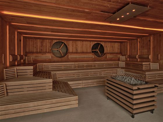 A modern sauna room with wooden benches and soft lighting. Two round windows create a relaxed atmosphere.