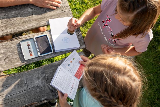 Kinder sammeln beim Wandern Stempel in einem Stempelpass