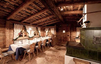 Ein gemütliches Restaurant mit Holzwänden und einem großen Tisch. Der Raum ist warm und einladend, ideal für ein rustikales Ess-Erlebnis.
