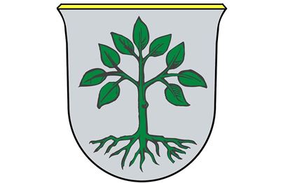 Ein Wappen mit einem grünen Baum und Wurzeln auf grauem Hintergrund. Oben ist eine gelbe Linie zu sehen.