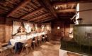 A cozy restaurant with wooden walls and a large table. The room is warm and inviting, ideal for a rustic dining experience.