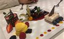 Ein aufregendes Dessert-Teller mit verschiedenen Leckereien wie Eis, Schokolade und frischen Früchten. Die bunte Anordnung macht das Gericht besonders einladend.
