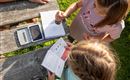 Kinder sammeln beim Wandern Stempel in einem Stempelpass