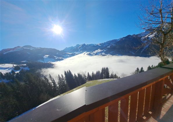 A beautiful view of a mountain landscape with fog and radiant sunshine. The view shows a tranquil and picturesque scene.