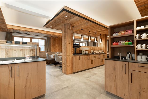Eine moderne Küche mit Holzverkleidung und einem gemütlichen Essbereich. Die Einrichtung ist stilvoll und einladend, ideal für gesellige Zusammenkünfte.