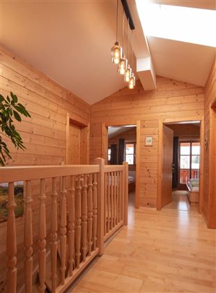 Ein heller Flur mit Holzverkleidung und mehreren Türen. Eine gemütliche Atmosphäre mit einer Pflanze und natürlichem Licht.