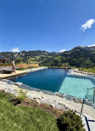 A beautiful pool in the mountains with clear water. The surroundings are green and offer a magnificent view of nature.