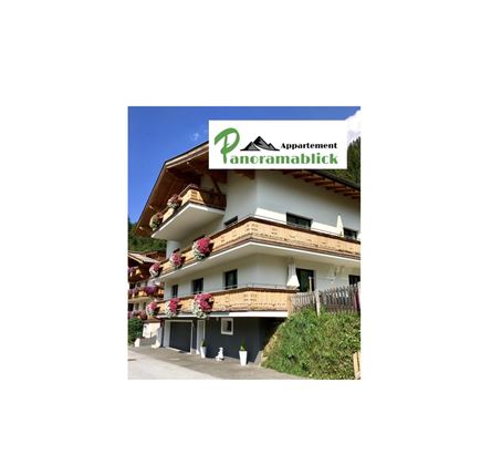 Ein modernes Appartementhaus mit Balkonen und blühenden Blumen. Das Logo "Appartement Panoramablick" ist deutlich sichtbar.