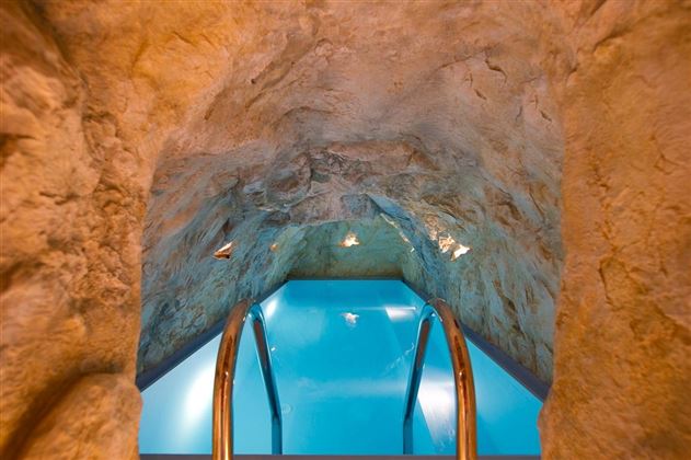 A unique underground pool with a natural rock arch. The clear water invites relaxation.