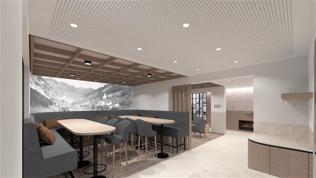 A modern interior with comfortable seating and a bright, inviting atmosphere. On the wall, there is a large, decorative painting of a mountain landscape.
