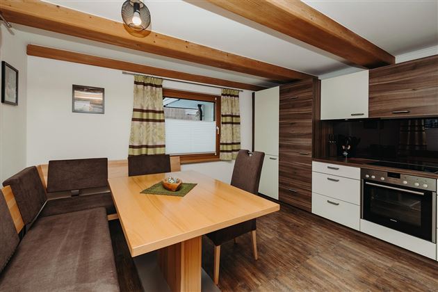 A modern kitchen with a large dining area. Wooden details and stylish furniture create a cozy atmosphere.