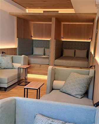 Ein moderner, einladender Raum mit bequemen Sofas und gemütlichen Sitzbereichen. Sanfte Beleuchtung sorgt für eine entspannte Atmosphäre.