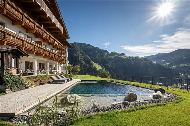 Ein modernes Hotel mit einem Pool und einer schönen Aussicht auf die Berge. Die klare Luft und die Sonne schaffen eine entspannte Atmosphäre.