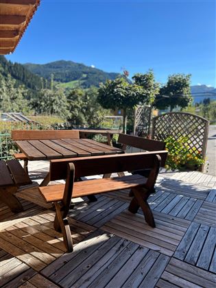 Terrasse mit Möbel, Aussicht auf die Grossarler Berge und blauer Himmel.