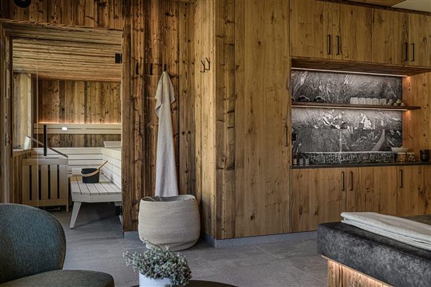 A modern spa with wood paneling and a sauna. The room is designed to be cozy and inviting.
