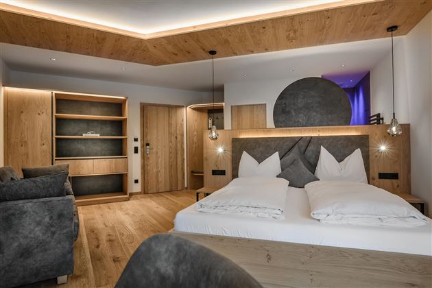 Ein modernes Schlafzimmer mit Holzdekor und einer gemütlichen Atmosphäre. Die Einrichtung ist stilvoll und bietet eine entspannende Umgebung.