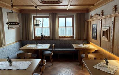 Ein gemütlicher Innenraum mit holzverkleideten Wänden und Tischen.