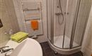 A modern bathroom with a shower and a sink. Towels in various colors are ready.
