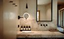 An elegant bathroom with a marble washbasin and modern fittings. In the background, there is a mirror with a lighted frame.