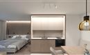 A modern apartment with one bedroom and an open kitchen. The decor is bright and minimalist, with a dining table and stylish light sources.