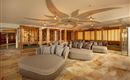 A stylish wellness area with comfortable lounge sofas and a warm ambiance. Large windows let gentle light in and create a relaxing atmosphere.