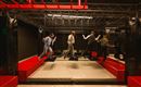 A trampoline hall with several bouncing elements. Four people are having fun playing and balancing.