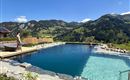 A beautiful pool in the mountains with clear water. The surroundings are green and offer a magnificent view of nature.