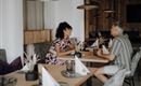 A cozy restaurant with wooden decor. Two people, a woman and a man, are sitting at the table and having a friendly conversation.