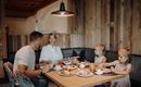 A cozy breakfast with a family at the table. The table is adorned with various foods and drinks.