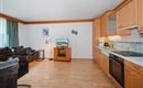 A bright and modernly furnished apartment with hardwood floors. The kitchen is well-equipped and there is a cozy seating area.
