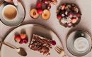 Eine leckere Auswahl an Desserts auf einem Tisch. Dazu gehören Kuchen, frisches Obst und Kaffee.