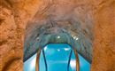 A unique underground pool with a natural rock arch. The clear water invites relaxation.