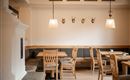 Ein gemütliches Restaurant mit Holztischen und Bänken. An der Wand hängen dekorative Geweihstücke.
