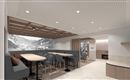 A modern interior with comfortable seating and a bright, inviting atmosphere. On the wall, there is a large, decorative painting of a mountain landscape.