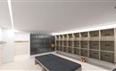 A modern changing room with wooden doors and a bench area. The walls are light, and in the background, lockers with numbers are visible.