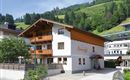 A charming alpine house with wooden cladding and balconies. Surrounded by green mountains and a peaceful atmosphere.