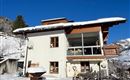 Ein modernes Haus im Schnee mit einem klaren blauen Himmel. Die Umgebung ist winterlich und ruhig.