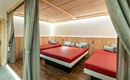Ein modernes Schlafzimmer mit drei Einzelbetten und einem warmen Holzdesign. Die sanfte Beleuchtung schafft eine einladende Atmosphäre.