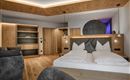 Ein modernes Schlafzimmer mit Holzdekor und einer gemütlichen Atmosphäre. Die Einrichtung ist stilvoll und bietet eine entspannende Umgebung.
