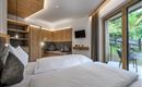 Ein modernes Zimmer mit zwei Betten und Holzverkleidung. Große Fenster bieten einen Blick ins Freie und sorgen für viel Tageslicht.