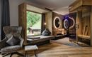 Ein modernes Zimmer mit großen Fenstern und einer gemütlichen Sitzecke. Die Sauna ist ebenfalls gut sichtbar und fügt dem Raum eine entspannende Atmosphäre hinzu.